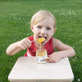 A girl eating raw honey from the jar