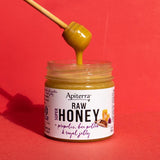 A honey dipper coming out from a propolis, bee pollen & royal jelly honey jar